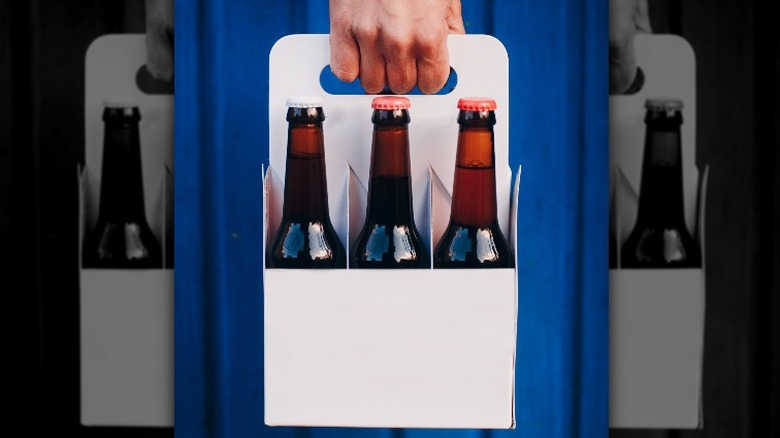 Hand carrying beer six pack