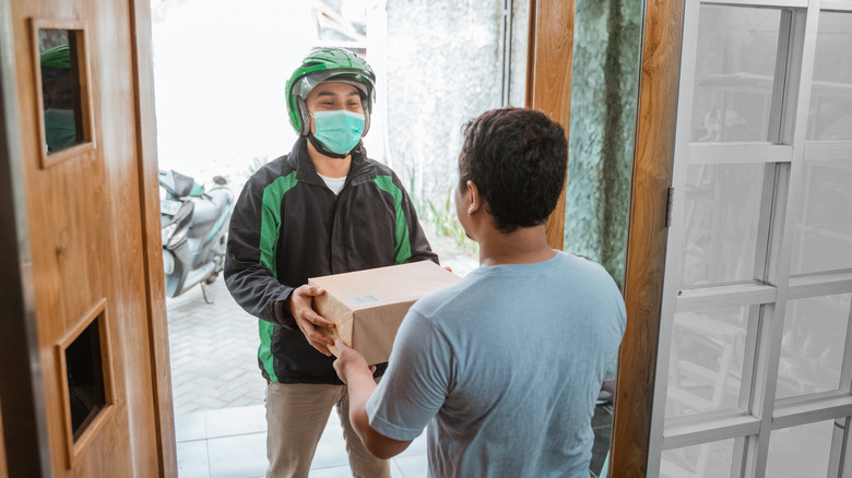 Man in mask delivering package 