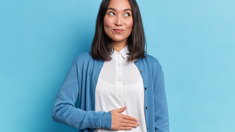 Woman smiling with hand on belly