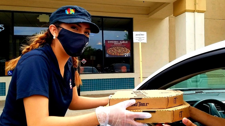 employee holding pizza box