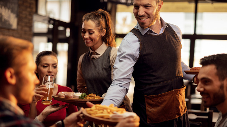 waiter and waitress serving table