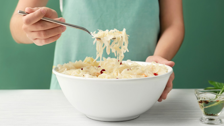 woman eating sauerkraut from bowl