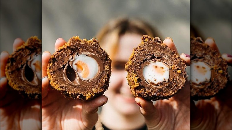 Girl holding cut Scotch egg creme