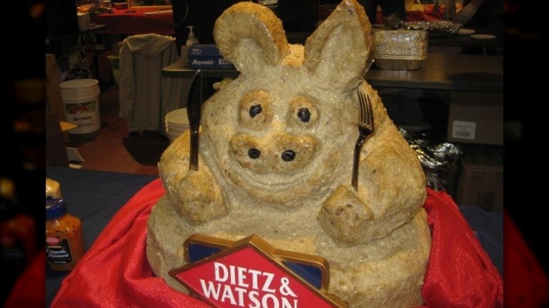 A grey pig made of scrapple holding a fork and knife