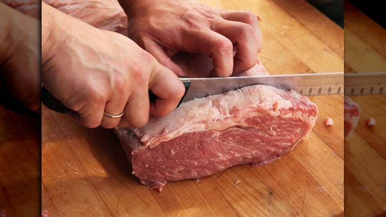 Hand slicing into a steak