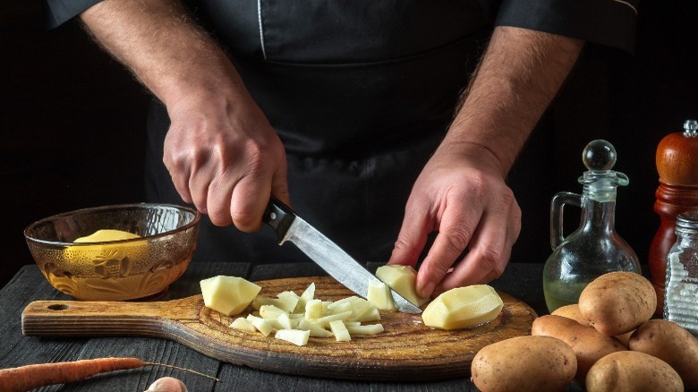 Chef slicing potatoes