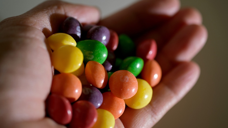 Hand holding big bunch of Skittles