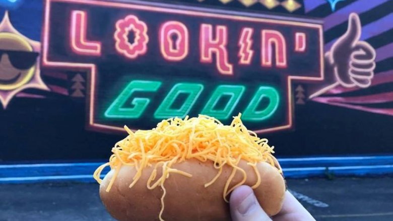 A Skyline Chili coney in front of a "lookin' good" sign