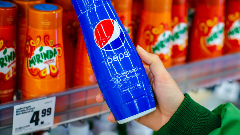 Hand holding Pepsi-flavored SodaStream concentrate