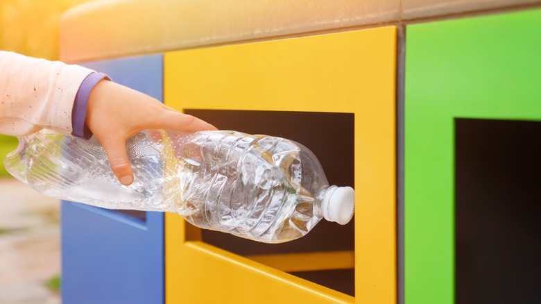 hand recycling empty plastic bottle