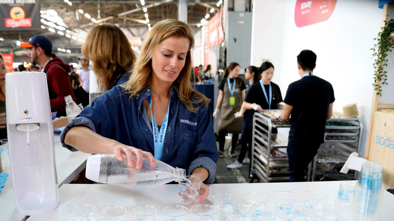 woman pouring SodaStream water into cup