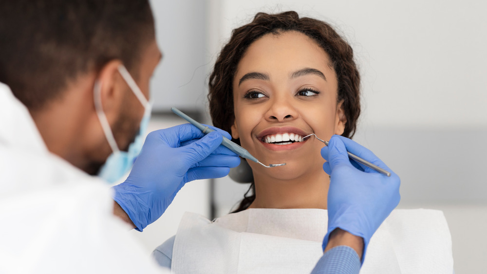 A woman getting a cleaning from a dentist