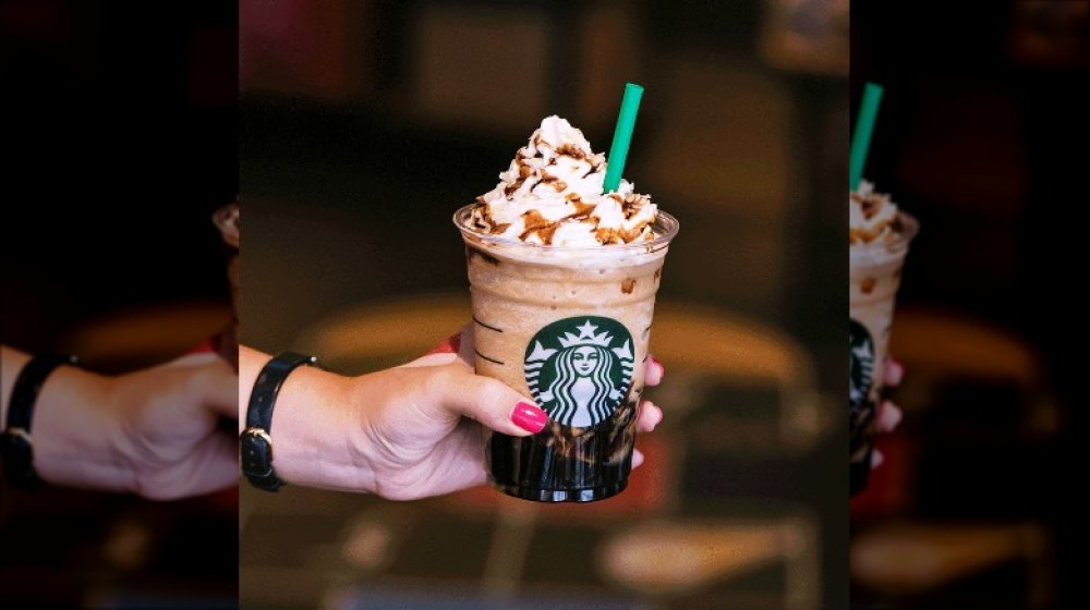 holding a starbucks frappuccino