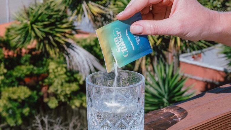 sun chaser packet hand pouring into glass