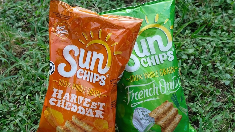 two bags of Sun Chips on grass