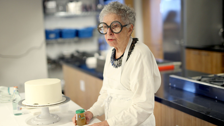 Sylvia Weinstock standing next to a white cake