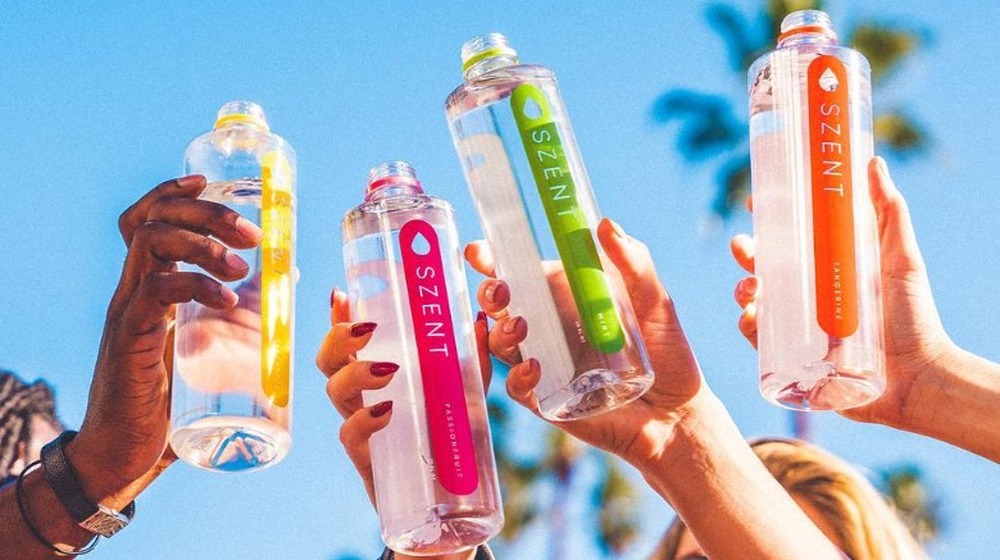 Arms lifting up four different flavors of Szent water