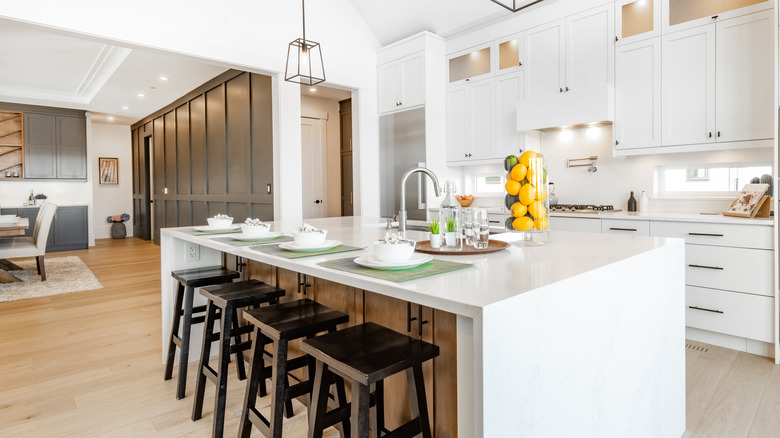 clean white kitchen with island stools and lemons