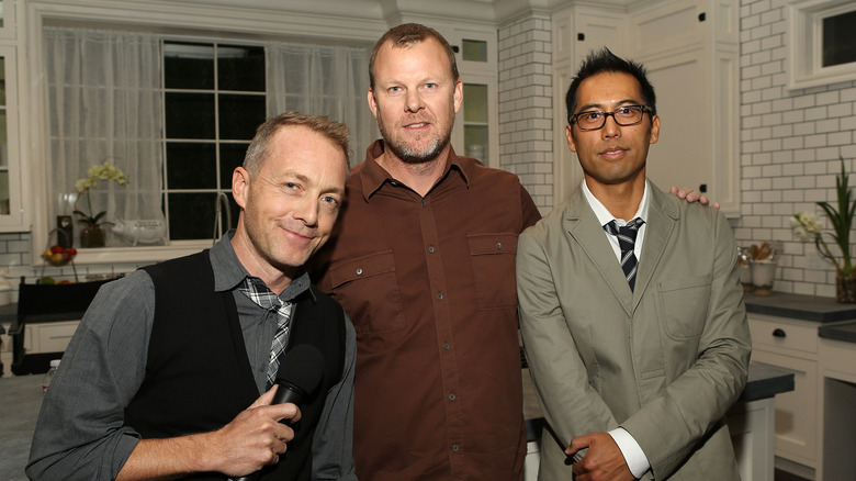 three men standing in kitchen