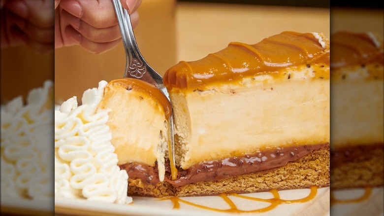 fork going into slice of salted caramel cheesecake