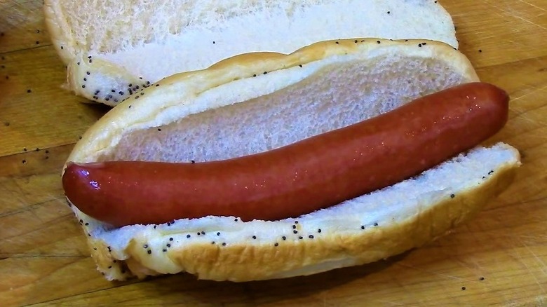 close up of steamed Vienna Beef hot dog in steamed poppy seed bun on wooden cutting board