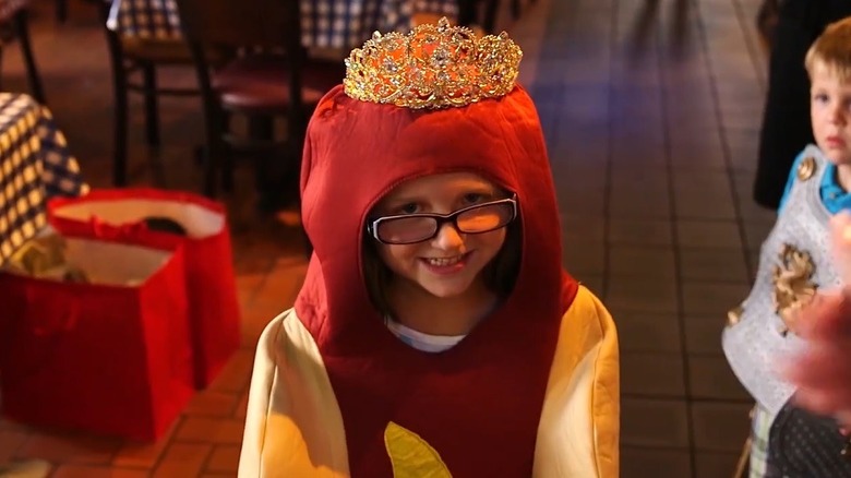 screenshot of 7 year old Ainsley Turner dressed in hot dog costume with tiara on her head after being crowed Hot Dog Queen of Chicago by Portillos