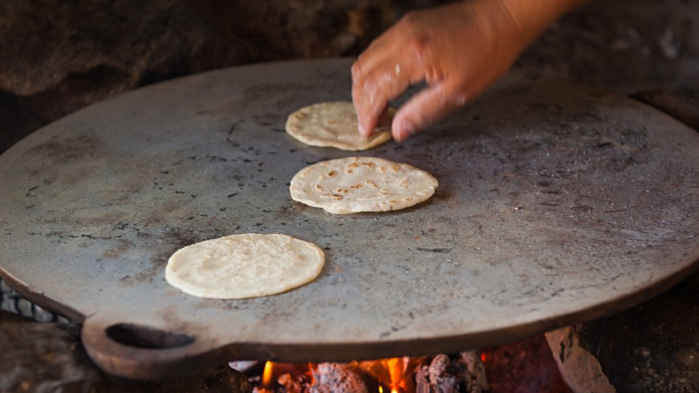 Tortilleria, person making tortillas on a comal