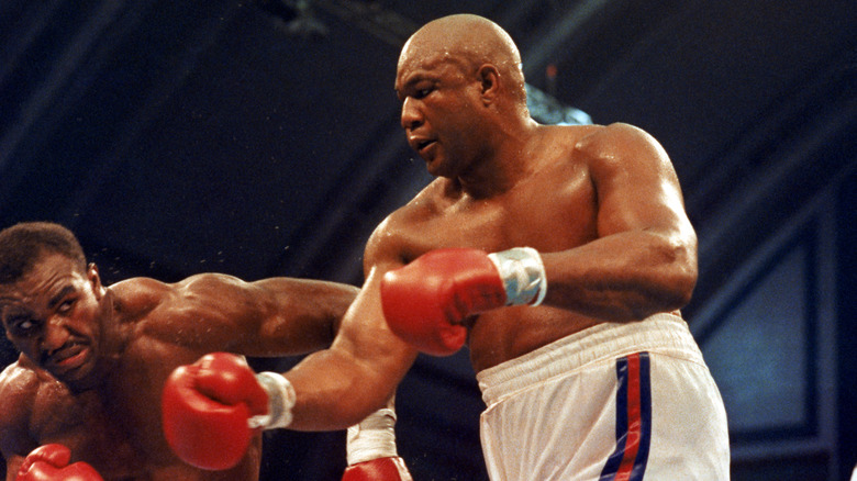 Evander Holyfield (left) avoids a right punch by George Foreman as they compete for the WBC, WBA, IBF Heavyweight Titles, in a bout schedule for twelve rounds at the Trump Plaza Convention Center on April 19, 1991 in Atlantic City, New Jersey.