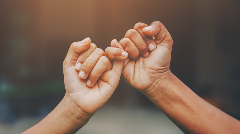 Hands holding pinkies