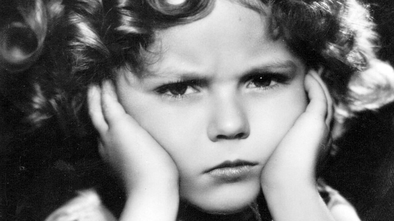 sad shirley temple holding face