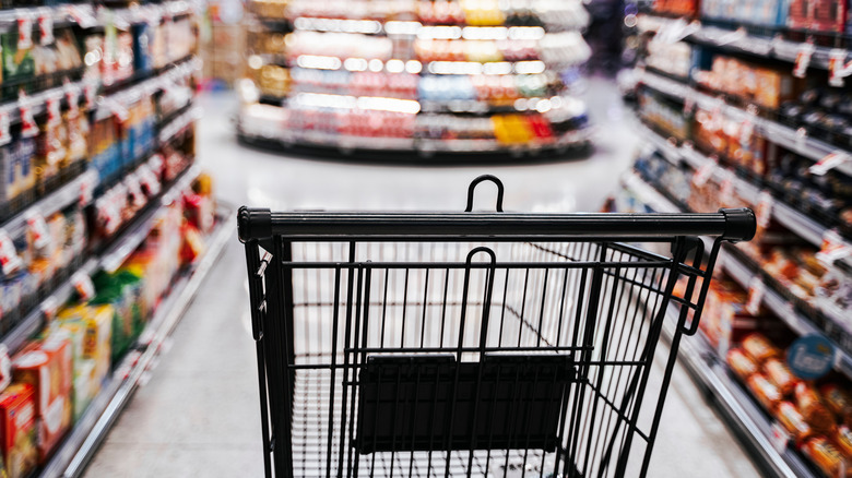 empty cart in supermarket aisle