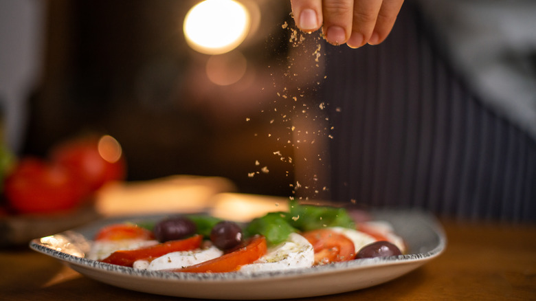 Chef plating dish and sprinkling garnish