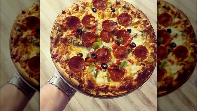 Person holding a Tombstone pizza