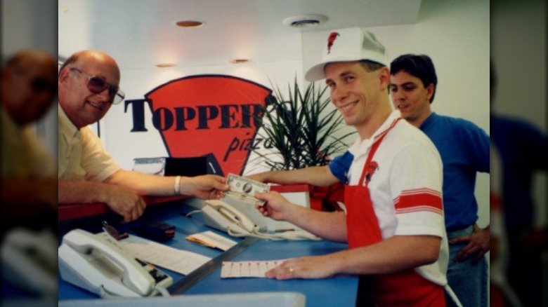 A Old image of a Toppers Cashier performing a transaction