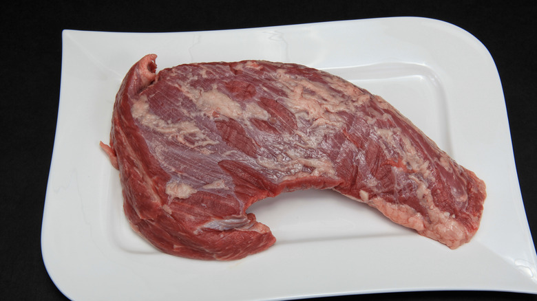 raw tri tip steak on white plate