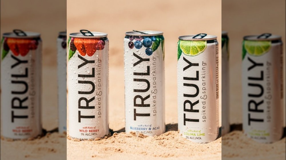 Cans of Truly Hard Seltzer in the sand 