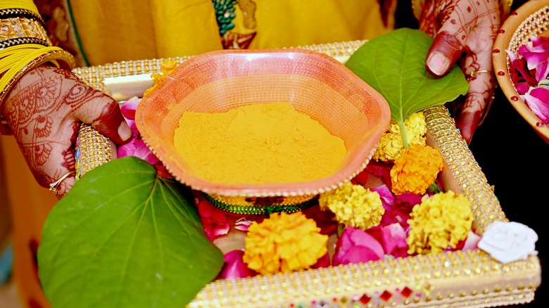 Turmeric and flowers in tray