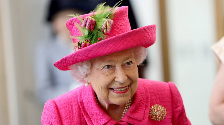 Queen Elizabeth wearing a pink hat and dress