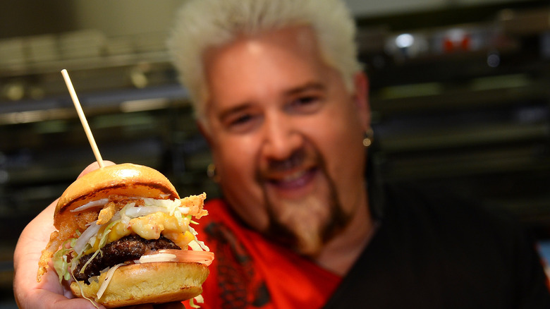 Guy Fieri holding a mini burger