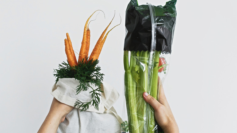 hands holding carrots and celery