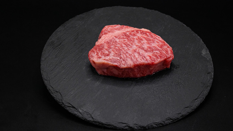 Slab of raw steak on a plate.