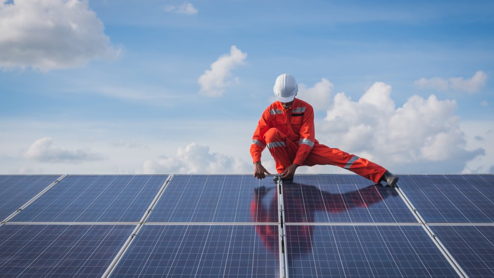 A man installs solar panels 