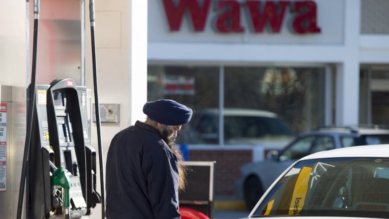 A man pumping gas at Wawa