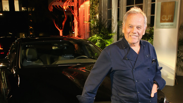 Wolfgang Puck in front of a car