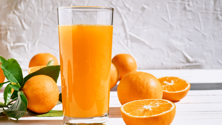 Glass of orange juice and oranges