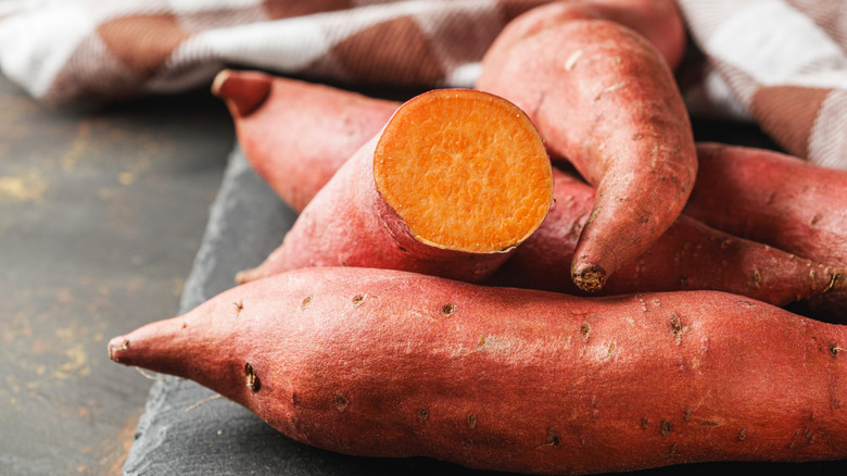 Raw sweet potatoes on a cutting board