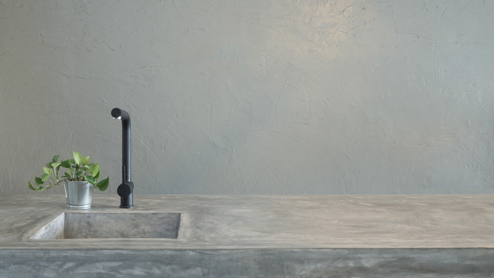 Concrete countertop and sink with black faucet