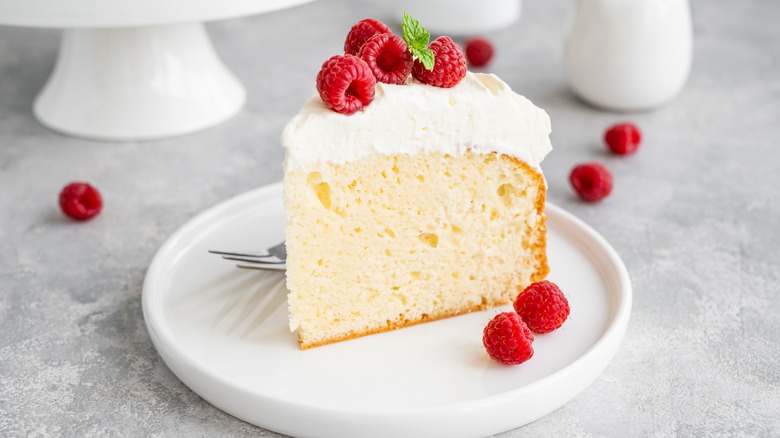 Slice of cake with cream and berries on plate