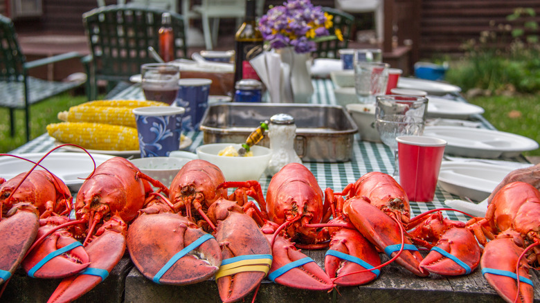 Picnic table feast with cooked lobsters