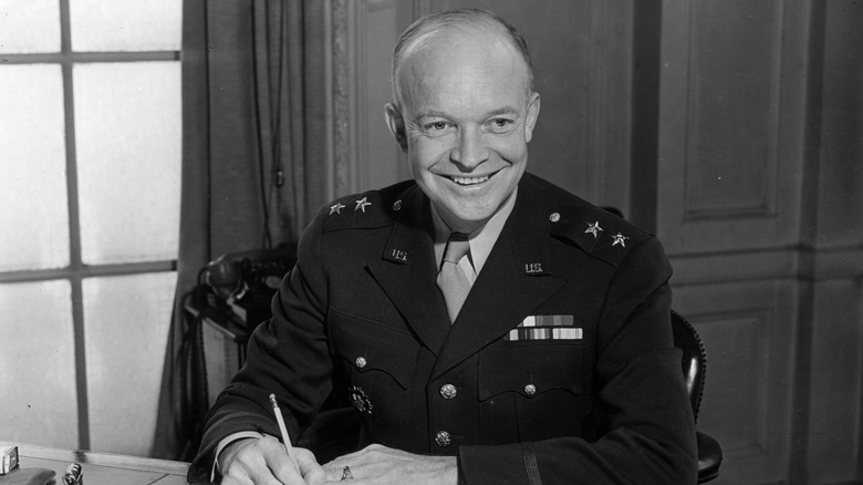 Dwight Eisenhower sitting at a desk writing